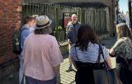 Residents listening to a guide on a historical walking tour.
